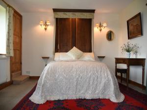 Manor Farm Egerton في Malpas: غرفة نوم مع سرير مع اللوح الأمامي الخشبي