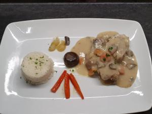 a white plate of food with mushrooms and carrots at Hôtel Restaurant Le Moulin de la Renne Adults Only proche Zoo de Beauval in Thésée