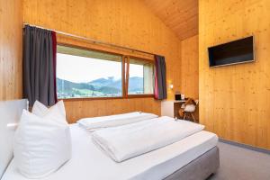 1 dormitorio con 2 camas blancas y ventana en Haus Deutinger en Flachau