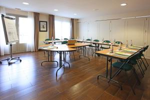 a classroom with tables and chairs and a projection screen at Campanile Angers Ouest - Beaucouzé in Beaucouzé