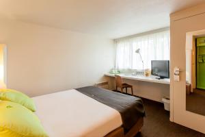 Ένα ή περισσότερα κρεβάτια σε δωμάτιο στο Campanile Angers Ouest - Beaucouzé