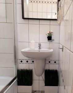 a white bathroom with a sink and a mirror at W Rynku in Wrocław