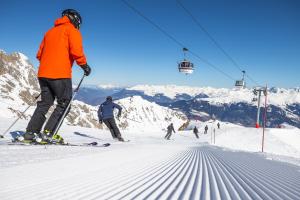 a group of people skiing down a snow covered mountain at Lodge Les Merisiers in Courchevel