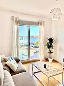 uma sala de estar com um sofá e vista para o oceano em Apartamento Mirando al Guadiana Centro em Ayamonte