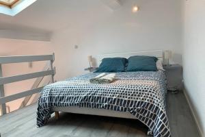 um quarto com uma cama grande e almofadas azuis em Duplex Carcassonne centre em Carcassonne