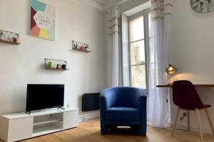 uma sala de estar com uma cadeira azul e uma televisão em Duplex Carcassonne centre em Carcassonne