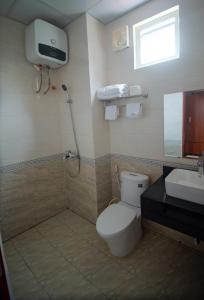 y baño con aseo, lavabo y ducha. en LUXURY HOSTEL, en Ha Giang
