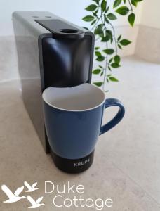 a coffee maker and a cup sitting on a counter at Duke Cottage in Fochabers