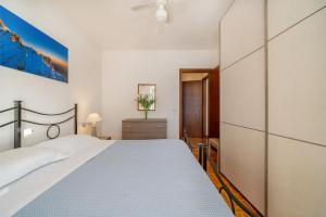 Un dormitorio con una gran cama blanca y una cómoda. en Casa Pergola, en Varenna