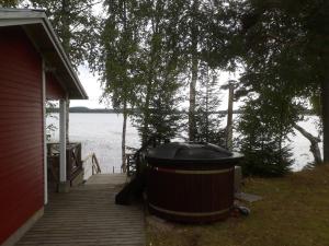 a large tub sitting on a dock next to a house at Villa Kotiranta in Jämsä