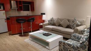 ein Wohnzimmer mit Sofa, Stühlen und einem Tisch in der Unterkunft رميس للشقق المخدومة 2 in Buraida
