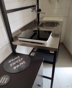 une cuisine avec un évier et un comptoir avec un ordinateur portable dans l'établissement Casa vacanze San Giovanni nei Sassi, à Matera