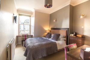 a bedroom with a bed and a window at Annandale Guest House in St Andrews