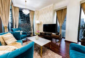 uma sala de estar com mobiliário azul e uma televisão de ecrã plano em FIRST CLASS 3BR with full BURJ KHALIFA and FOUNTAIN VIEW em Dubai