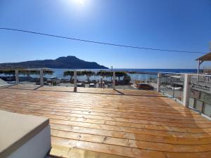 a wooden deck with the beach in the background at Notus Suites in Plakias