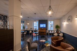 a lobby with chairs tables and a dining room at Logis Hôtel Au Croissant in Buzançais