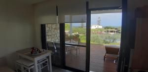 a living room with a view of a wooden deck at Artemis Village Apartments & Studios in Stavros