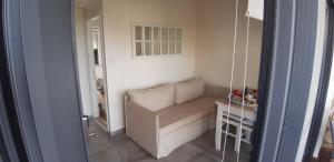 a small living room with a couch and a mirror at Artemis Village Apartments & Studios in Stavros
