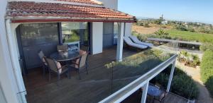 a deck with a table and chairs on a house at Artemis Village Apartments & Studios in Stavros