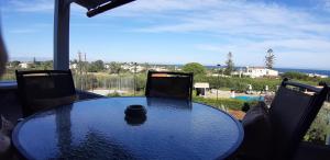 a table and chairs with a view of the ocean at Artemis Village Apartments & Studios in Stavros