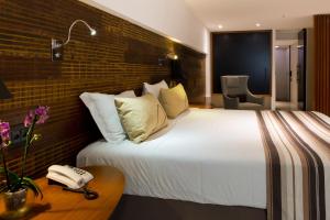 a hotel room with a large bed and a telephone at Ritz Leblon in Rio de Janeiro