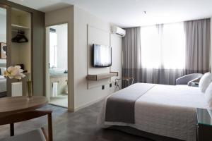 Cette chambre comprend un lit et une télévision. dans l'établissement Ritz Leblon, à Rio de Janeiro