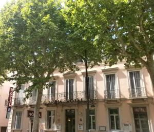 un edificio con árboles delante de él en Hôtel Le Victoria, en Draguignan