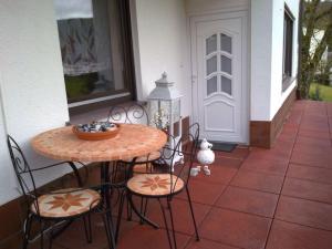 a table with chairs and a bowl of grapes on a patio at Ferienwohnung Patry in Leonhardshof