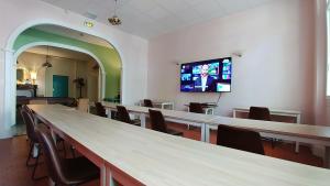 a room with tables and chairs and a tv on the wall at Hôtel Le Victoria in Draguignan