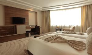 a hotel room with two beds and a television at Le Palace d'Anfa in Casablanca