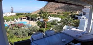 einen Balkon mit Pool- und Bergblick in der Unterkunft Artemis Village Apartments & Studios in Stavros