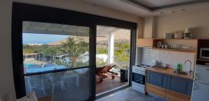 a kitchen with a sliding glass door leading to a patio at Artemis Village Apartments & Studios in Stavros
