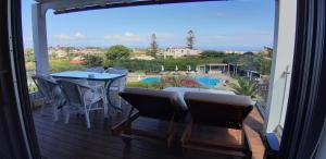 a balcony with a table and chairs and a view of a pool at Artemis Village Apartments & Studios in Stavros