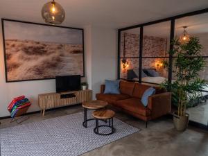 a living room with a couch and a bed at De Boulevard 2 in Zandvoort