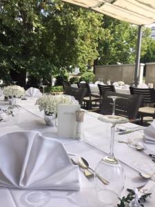 a table with white plates and silverware on it at Hotel An der Linde in Neckarsulm