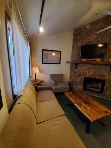 a living room with a couch and a stone fireplace at GetAways at Snow Lake Lodge in Big Bear Lake