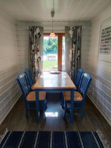 a dining room with a wooden table and chairs at Villa Kotiranta in Jämsä