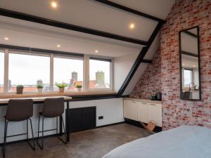 a loft conversion bedroom with a brick wall and a desk at De Boulevard 2 in Zandvoort