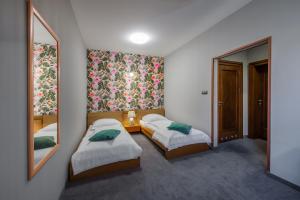 a bedroom with two beds and a mirror at Hotel Zalesie in Bochnia