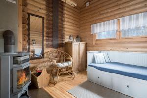una baita di tronchi con letto e camino di Ainola Cottage ad Alapitkä