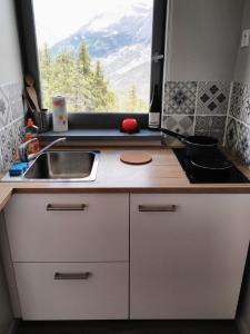 a kitchen with a sink and a window at Studio fonctionnel 16m2 avec vue panoramique in Puy-Saint-Vincent