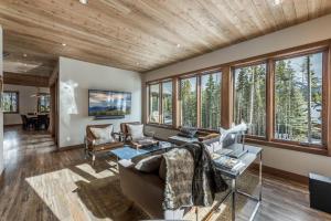a living room with wood ceilings and windows at Custom Ski In Ski Out Luxury Chalet - Hot Tub & Amazing Views - 500 Dollars Of FREE Activities & Equipment Rentals Daily in Winter Park