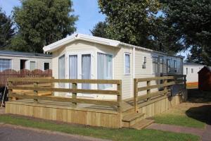 a tiny house with a wooden fence around it at The One - Chalet in the Cairngorms in Boat of Garten