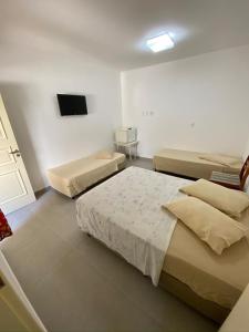 a bedroom with two beds and a television in it at Pousada Morada das Nações in Balneário Camboriú +47 photos