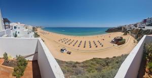 uitzicht op het strand vanaf het balkon van een gebouw bij Albufeira Beach Cliffs House in Albufeira