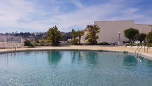 uma grande piscina de água em frente a um edifício em Albufeira, with terrace, see views, 5 min to beach (21) em Albufeira