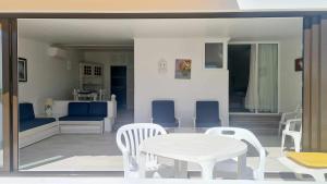 uma mesa e cadeiras brancas e uma mesa e uma mesa e uma mesa e cadeiras em Albufeira, with terrace, see views, 5 min to beach (21) em Albufeira