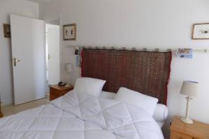 sypialnia z białym łóżkiem i czerwoną zasłoną w obiekcie La Corniche w mieście Agon-Coutainville