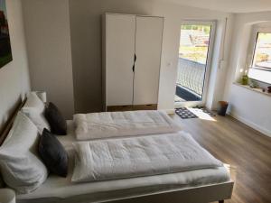 1 dormitorio con 2 camas y ventana grande en Bilderbuchcafe - Ferien Apartment NO 5 - Markt 7, en Havelberg