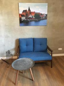 Bilderbuchcafe - Ferien Apartment NO 5 - Markt 7 في هافلبرغ: غرفة معيشة مع أريكة زرقاء وطاولة